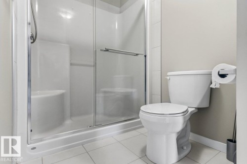 Glass-enclosed shower with integrated seating and a showerhead - 1807 Westerra Loop, Stony Plain, AB 