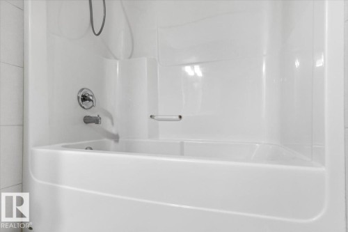 Integrated white bathtub and shower unit with chrome fixtures - 1807 Westerra Loop, Stony Plain, AB 