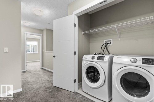 Laundry area with wire shelving, light gray wall paint, and gray carpeted flooring - 1807 Westerra Loop, Stony Plain, AB 