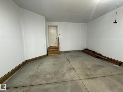Garage with concrete flooring, white painted walls, and a single paneled door - 1807 Westerra Loop, Stony Plain, AB 