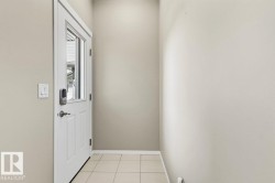 Entryway featuring a white door with an integrated window, smart lock, and neutral-toned wall paint - 