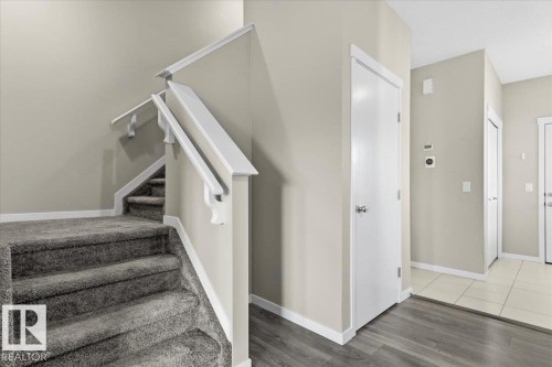 Carpeted staircase with white handrails, wood-finish flooring, and light-toned wall paint - 1807 Westerra Loop, Stony Plain, AB 