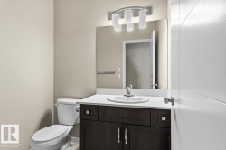 Dark wood-finish vanity with a white countertop, undermount sink, and chrome faucet - 