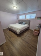 Wood-finish flooring, drop ceiling with recessed lighting, and two windows with blinds - 