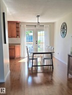 Wood-finish flooring throughout, light neutral wall tones, and recessed wood cabinetry with a countertop - 