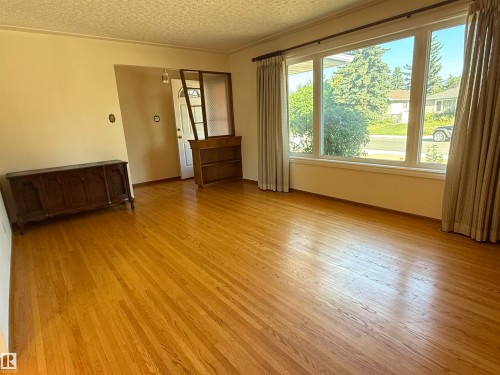 Spacious living room flooded with natural light through expansive windows and glass sliding doors - 7007 91 Avenue Nw, Edmonton, AB 