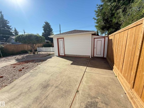 Spacious concrete driveway with direct access to a detached storage structure featuring dual doors and neutral siding - 7007 91 Avenue Nw, Edmonton, AB 