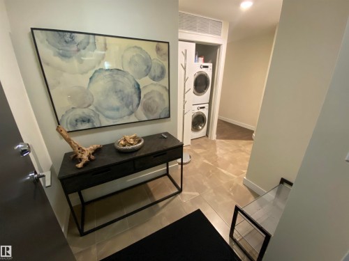 Tile flooring throughout, recessed lighting, and a dedicated laundry area with stacked appliances - #308 9907 91 Av Nw, Edmonton, AB 