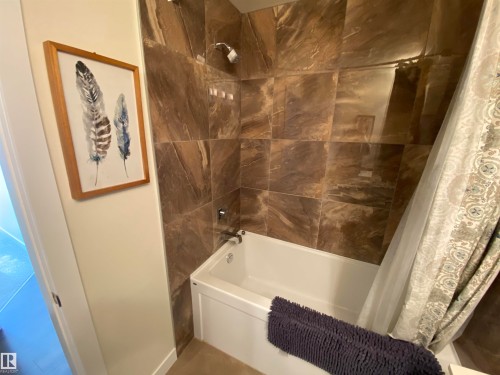 Built-in bathtub with a tile surround and chrome fixtures - #308 9907 91 Av Nw, Edmonton, AB 