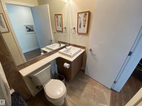 Dual vanity with rectangular vessel sinks, extensive countertop space, wood-finish cabinetry, and tiled flooring - #308 9907 91 Av Nw, Edmonton, AB 