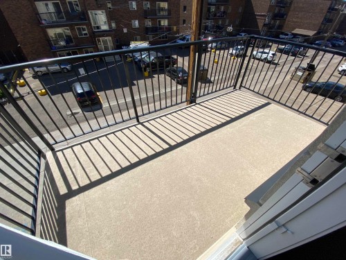 Outdoor balcony with a light-colored concrete surface and dark metal railings - #308 9907 91 Av Nw, Edmonton, AB 