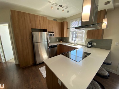 Wood-finish cabinetry paired with stainless steel appliances - #308 9907 91 Av Nw, Edmonton, AB 