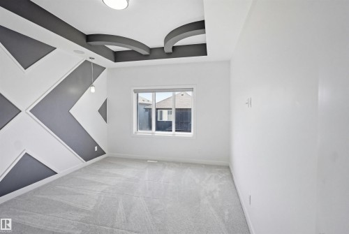 Accent wall with geometric paneling, recessed lighting, drop pendant light fixture, and window with roller shade - 2027 13 Avenue Nw, Edmonton, AB 