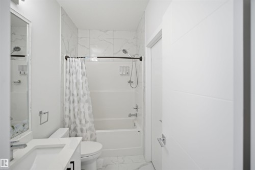 White vanity with integrated sink, chrome faucet, and mirrored medicine cabinet - 2027 13 Avenue Nw, Edmonton, AB 