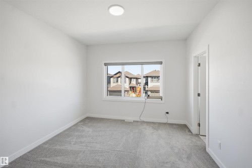 Neutral wall finishes, recessed ceiling light, window with roller shade, and gray carpeting - 2027 13 Avenue Nw, Edmonton, AB 