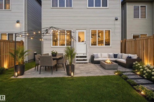 Paved patio area, manicured lawn, stone pathway, wood fencing, and exterior lighting - 2027 13 Avenue Nw, Edmonton, AB 