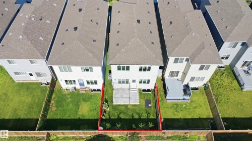 Expansive green space featuring a concrete patio, wood fencing, and mature landscaping - 2027 13 Avenue Nw, Edmonton, AB 