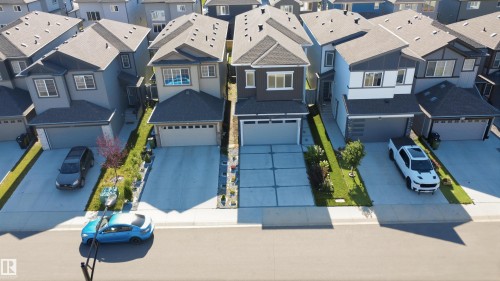 Contemporary exterior with a dark gray and white facade, integrated garage, and a concrete driveway - 2027 13 Avenue Nw, Edmonton, AB 