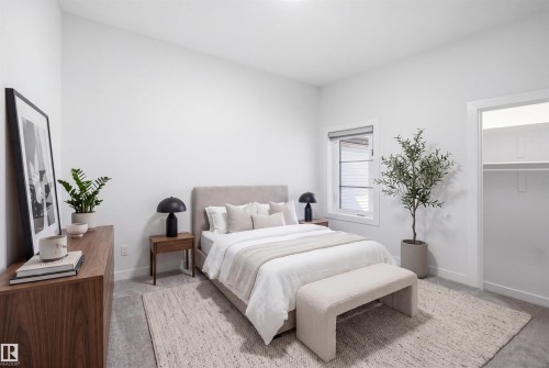 Well-lit bedroom with a single window, carpet flooring, and a built-in closet featuring shelving and a hanging rod - 2027 13 Avenue Nw, Edmonton, AB 