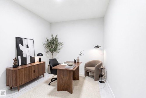 Bright interior room with white walls and a light-colored floor, featuring a built-in overhead light fixture - 2027 13 Avenue Nw, Edmonton, AB 