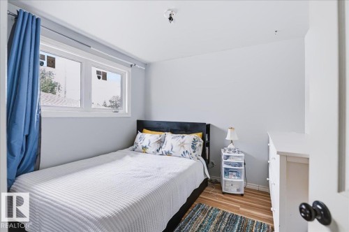 Dual-pane window, wood-finish flooring, light gray wall paint, and white trim - 12919 135 Avenue Nw, Edmonton, AB 