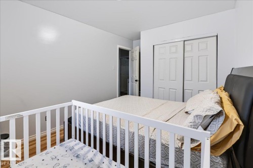 Wood-finish flooring, white walls, and a sliding two-panel closet door - 12919 135 Avenue Nw, Edmonton, AB 