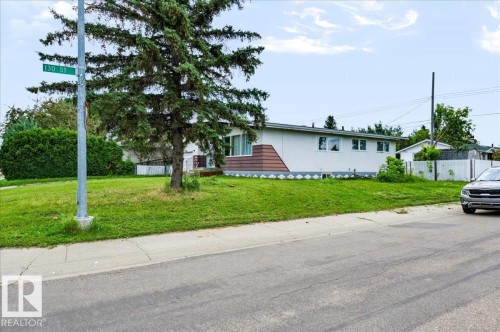 Single-story residence with white siding and a brown geometric accent panel - 12919 135 Avenue Nw, Edmonton, AB 