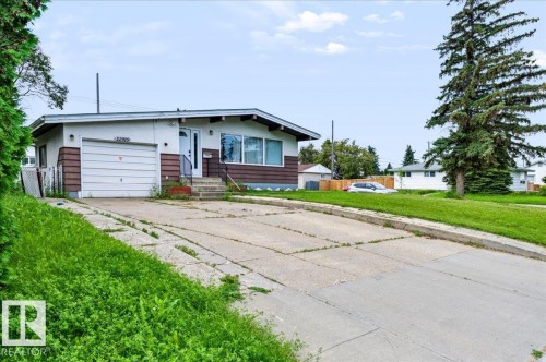 Single-story residence featuring a front entry, attached garage, and concrete driveway - 12919 135 Avenue Nw, Edmonton, AB 
