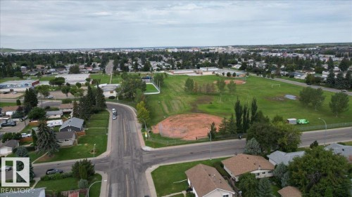 Neighborhood setting featuring detached residential homes, broad streets, and a prominent green space with sports fields - 12919 135 Avenue Nw, Edmonton, AB 