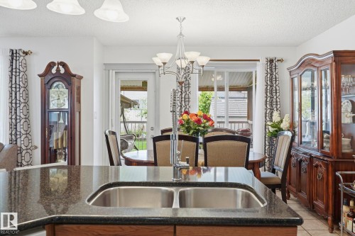 Spacious kitchen island with dual stainless steel sink and dark granite-style countertop - 3231 28A Avenue Nw, Edmonton, AB 