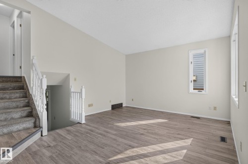 Spacious room featuring wood-finish flooring, light-toned walls, and a window providing natural illumination - 3722 34A Avenue Nw, Edmonton, AB - Indoor Photo Showing Other Room