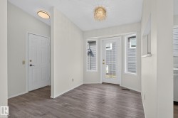 Dining area featuring wood-finish flooring, a crystal chandelier, and a bay window with a glass-paned door - 