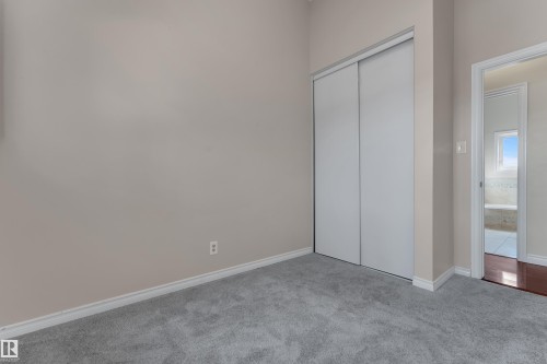 Carpeted room with a sliding door closet and light-toned walls - 8803 68A Street Nw, Edmonton, AB 