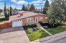 Brick exterior, attached garage, concrete driveway, mature trees, landscaped front yard - 8803 68A Street Nw, Edmonton, AB 