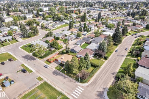 Residential neighborhood featuring mature trees, paved streets, and single-story homes with pitched roofs - 8803 68A Street Nw, Edmonton, AB 