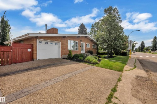Brick exterior with a single-car garage featuring decorative window inserts - 8803 68A Street Nw, Edmonton, AB 