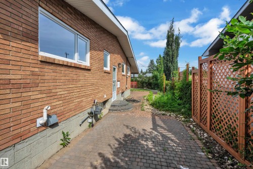 Brick exterior featuring multiple windows and a side entry - 8803 68A Street Nw, Edmonton, AB 