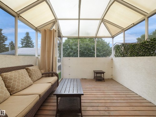Enclosed patio featuring a wood-finish floor, textured walls, and a translucent roof - 7435 32 Avenue Nw, Edmonton, AB 
