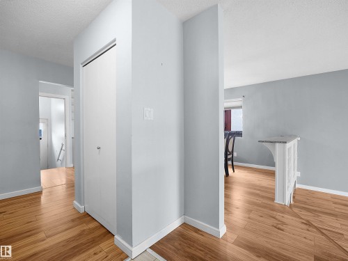 Wood-finish flooring throughout, with a built-in half-wall featuring a stone-finish countertop - 7435 32 Avenue Nw, Edmonton, AB 