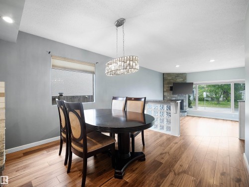 Wood-finish flooring throughout, frosted window for privacy, and a contemporary chandelier - 7435 32 Avenue Nw, Edmonton, AB 