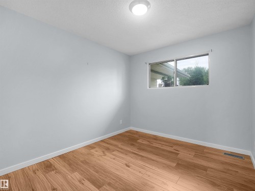 Wood-finish flooring with white trim, light gray painted walls, and a ceiling-mounted light fixture - 7435 32 Avenue Nw, Edmonton, AB 