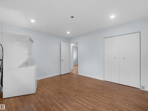 Wood-finish flooring throughout, recessed lighting, and bright white bi-fold closet doors - 7435 32 Avenue Nw, Edmonton, AB 