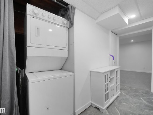 Stackable laundry appliances, drop ceiling, recessed lighting, and a durable tile-finish floor - 7435 32 Avenue Nw, Edmonton, AB 