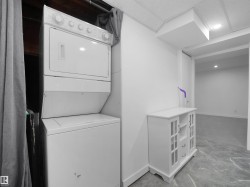 Stackable laundry appliances, drop ceiling, recessed lighting, and a durable tile-finish floor - 
