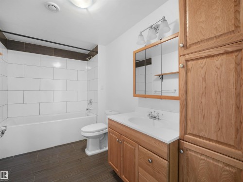 White subway tile tub surround with dark accent band - 7435 32 Avenue Nw, Edmonton, AB 