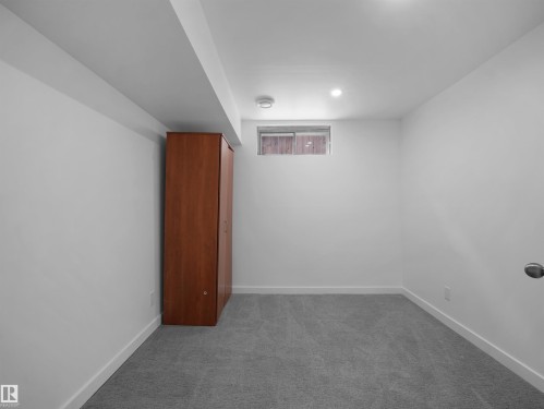 Recessed ceiling lighting, a window with wood-finish blinds, and light-grey carpeting - 7435 32 Avenue Nw, Edmonton, AB 