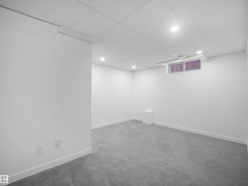 Recessed lighting illuminates this carpeted space with a drop ceiling and a window - 7435 32 Avenue Nw, Edmonton, AB 