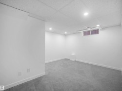 Recessed lighting illuminates this carpeted space with a drop ceiling and a window - 