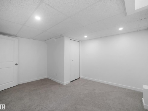 Recessed lighting illuminates the room, featuring light gray carpeting and white walls - 7435 32 Avenue Nw, Edmonton, AB 