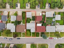 Property with two distinct structures, featuring a front yard with mature landscaping and a paved driveway - 